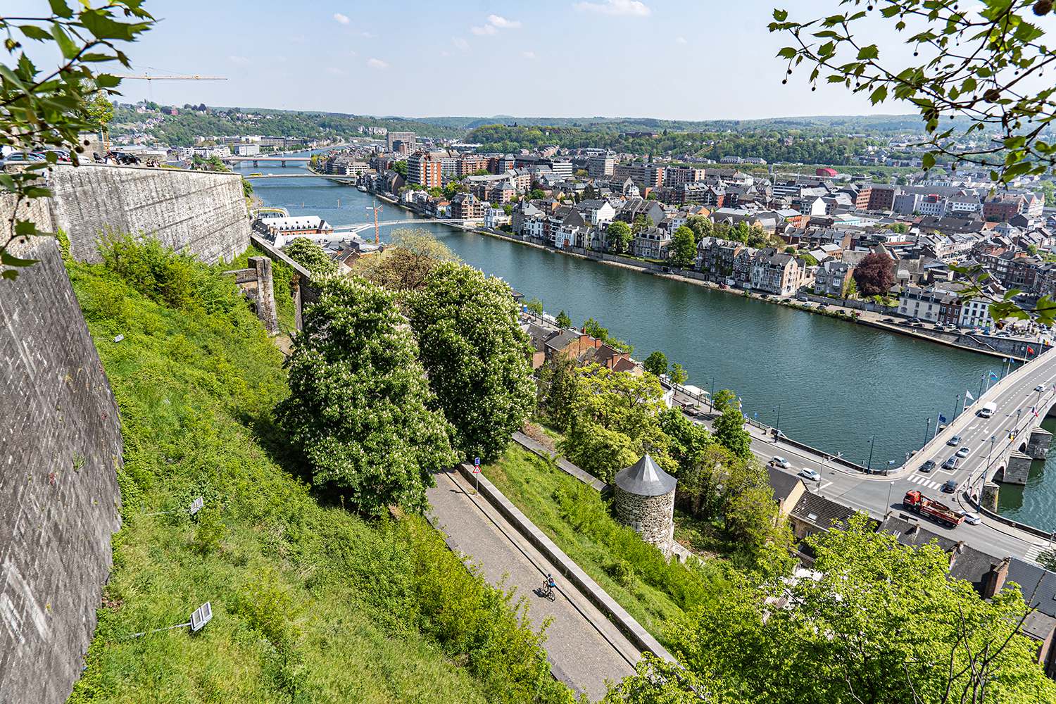 Wielrenner fietst de citadel van Namen op met prachtig uitzicht over de Maas en de stad