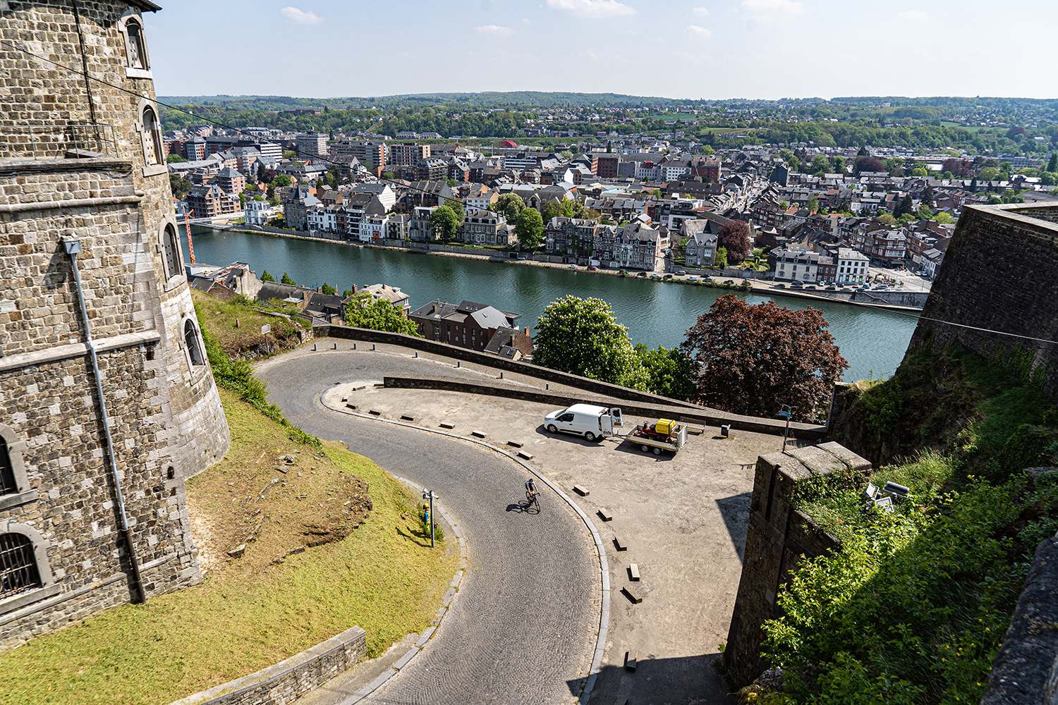 Fietsvakantie in België: wielrenner fietst de citadel van Namen op met prachtig uitzicht over de Maas en de stad