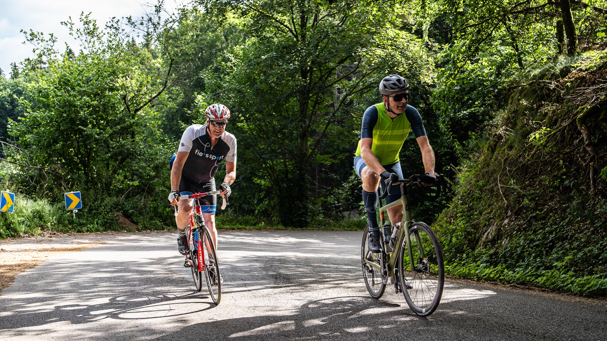 Twee fietsers beklimmen een heuvel in de Eifel tijdens fietsvakantie Road to Basel.