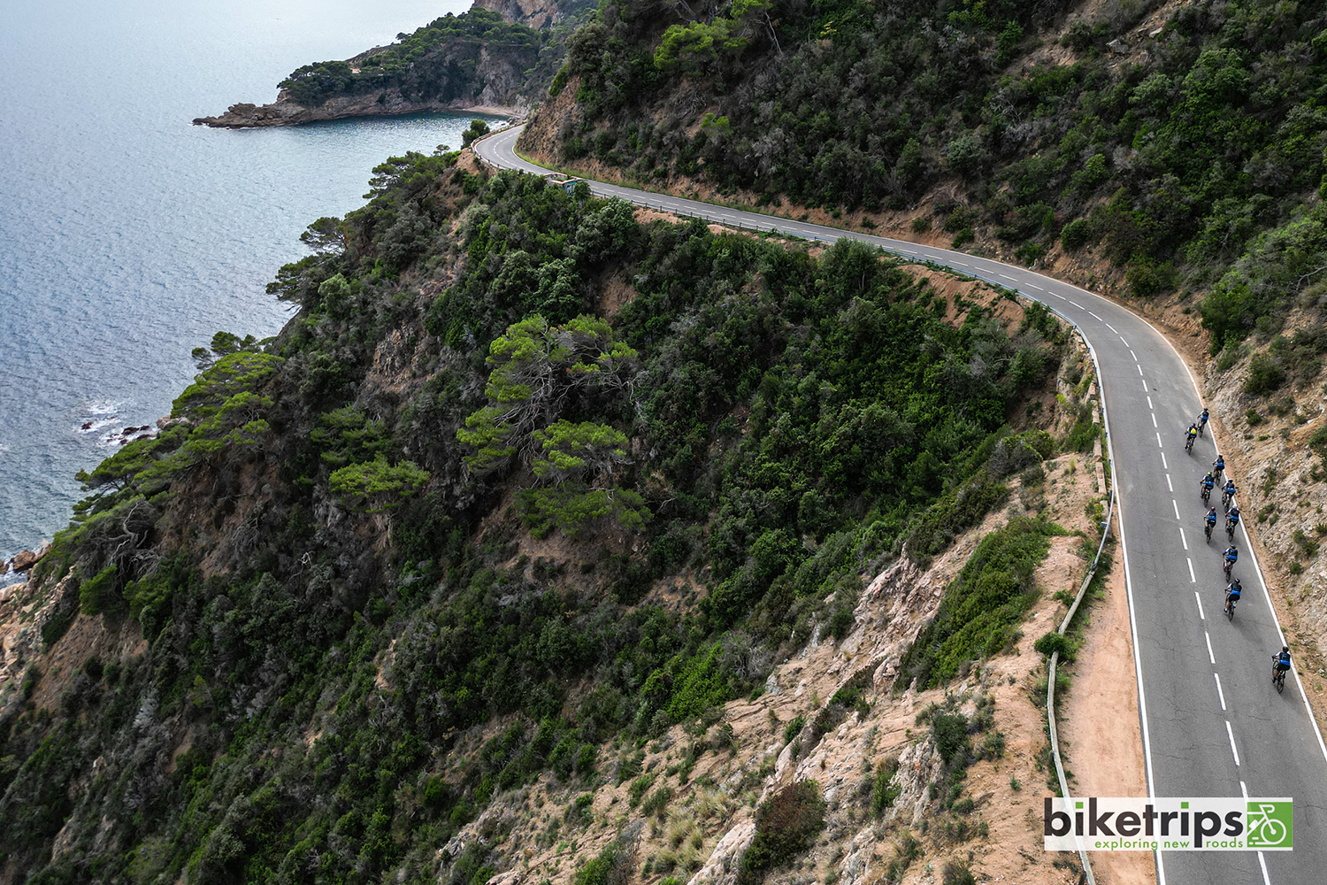 Dronefoto van fietsers op kustweg Costa Brava