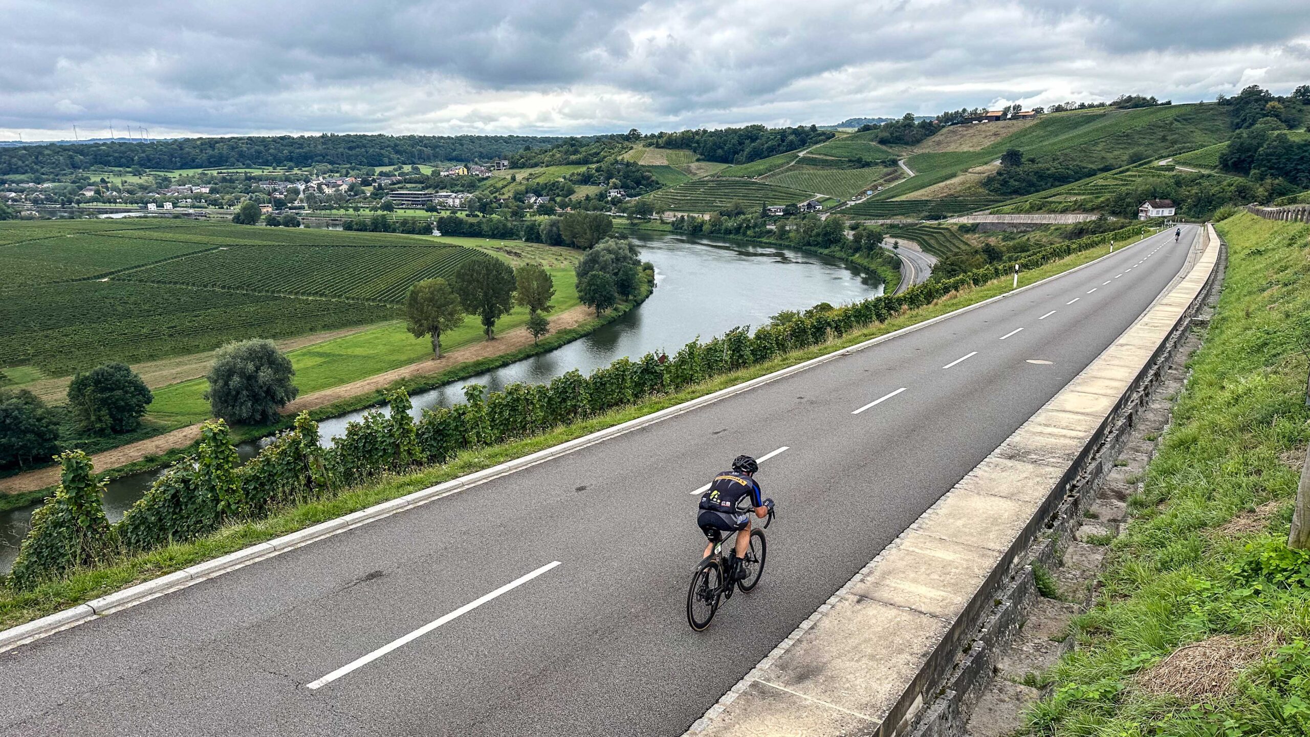 Deelnemer daalt af van heuvel naar Moezel in Luxemburg tijdens groepsreis Road to Basel