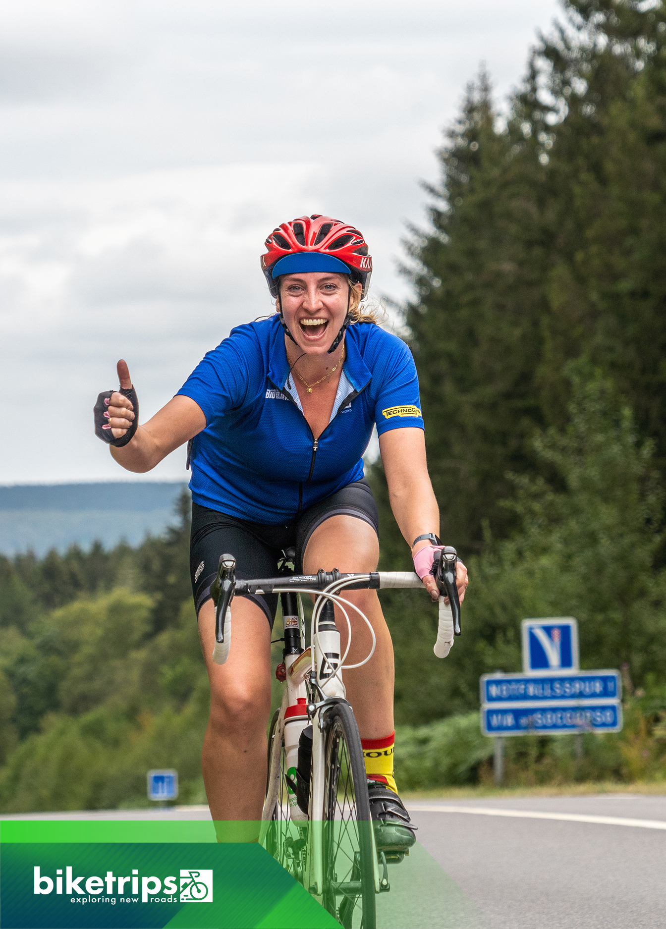 Een blije wielrenster die op fietsvakantie is in Frankrijk. Ze fietst op een racefiets.