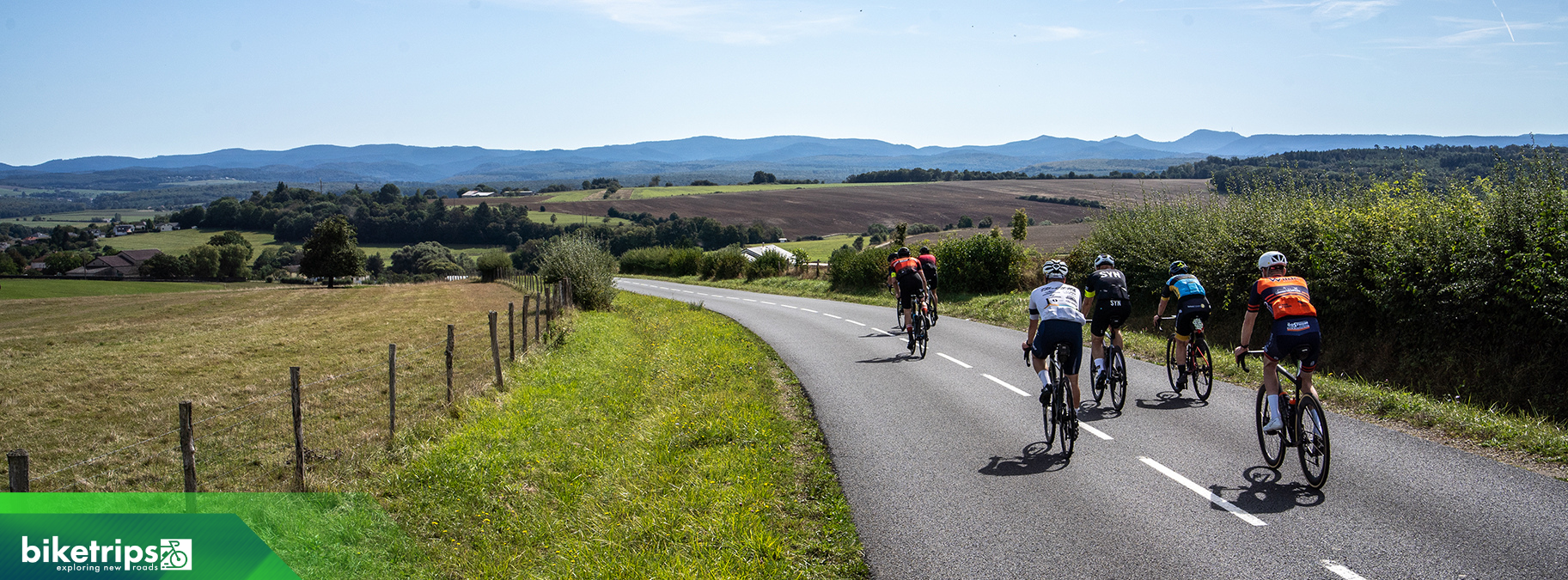 Groep fietsers daalt af met berglandschap Vogezen op achtergrond