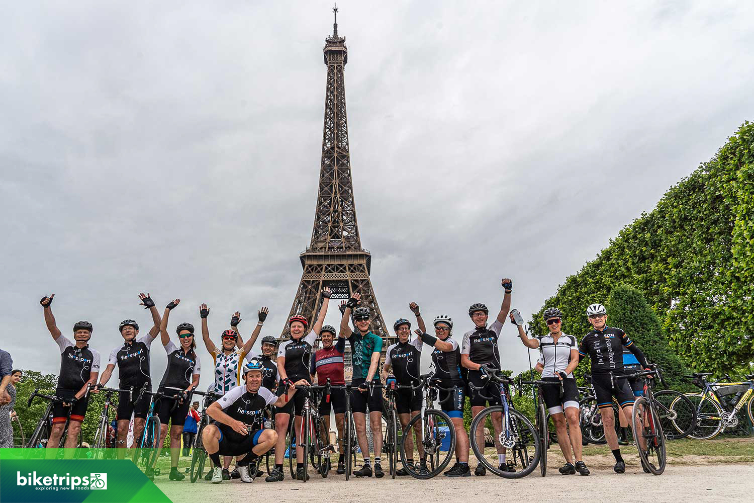 Groepsfoto van fietsers voor de Eiffeltoren op fietsvakantie