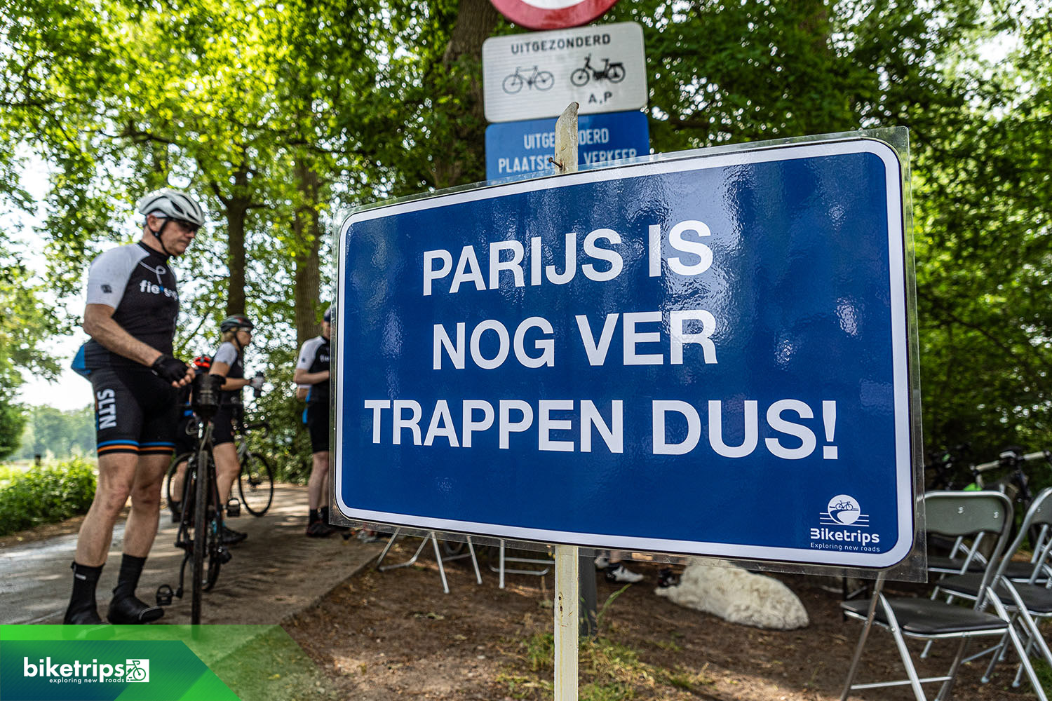 Bord met opschrift Parijs is nog ver, trappen dus! Tijdens fietsvakantie Road to Paris