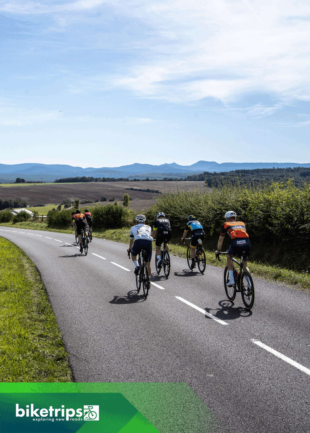 Groep fietsers daalt af met berglandschap Vogezen op achtergrond