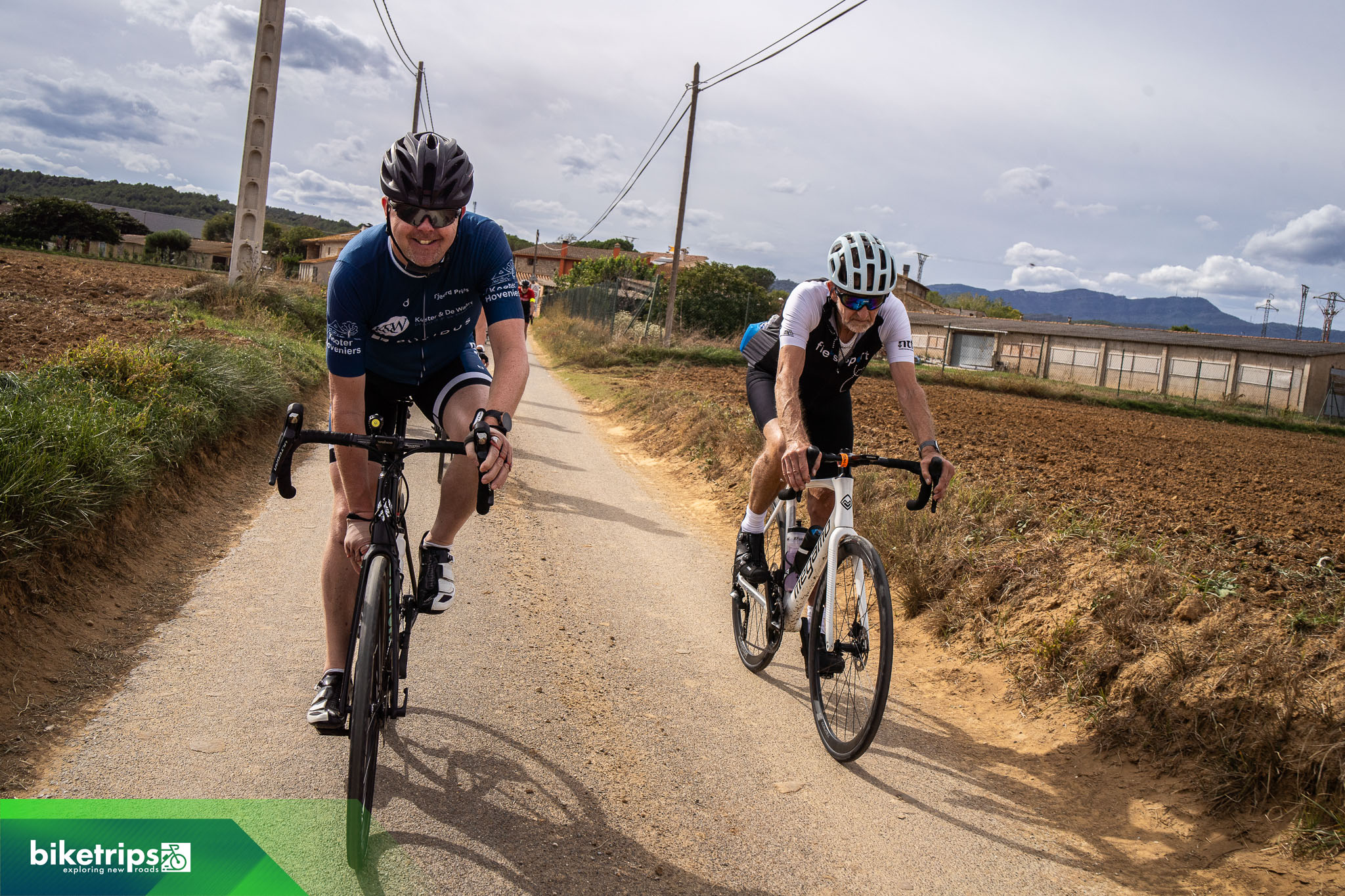 Fietsers fietsen over landweg bij Girona tijdens fietsvakantie Spanje