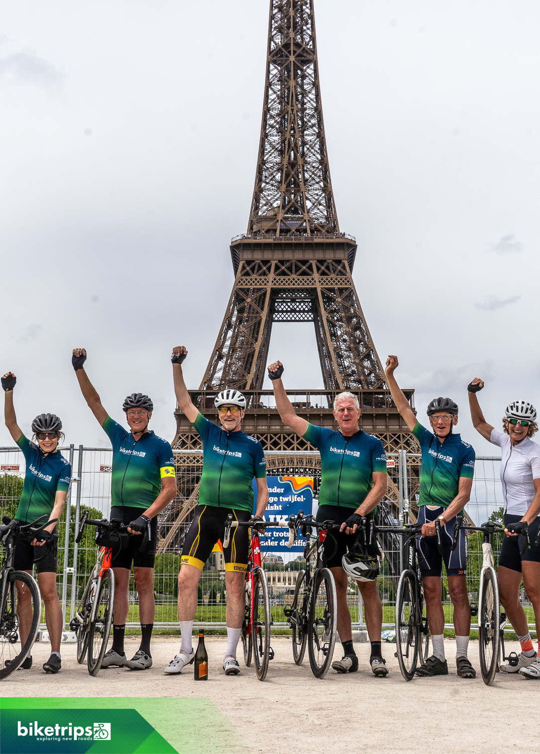 Een groep wielrenners is bij de Eiffeltoren aangekomen na een fietsvakantie van Nederland naar Parijs.