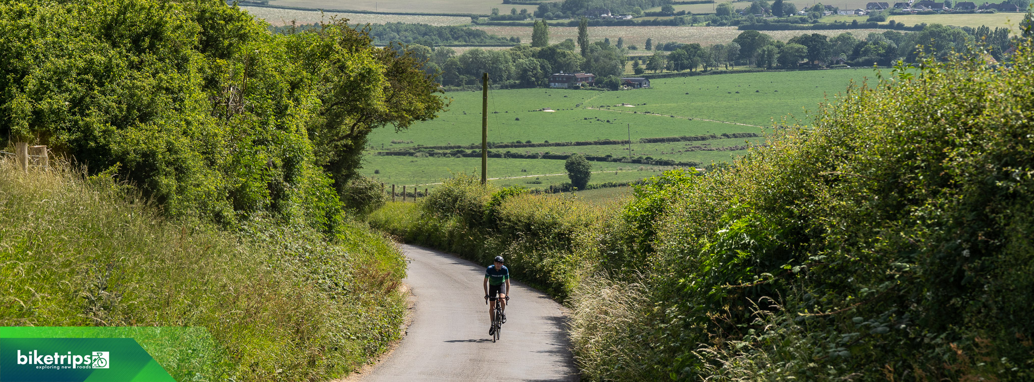 Fietser fietst langs golvende weilanden in Kent Downs National Landscape